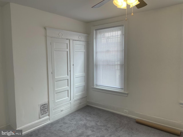 unfurnished bedroom with ceiling fan, carpet flooring, and a closet