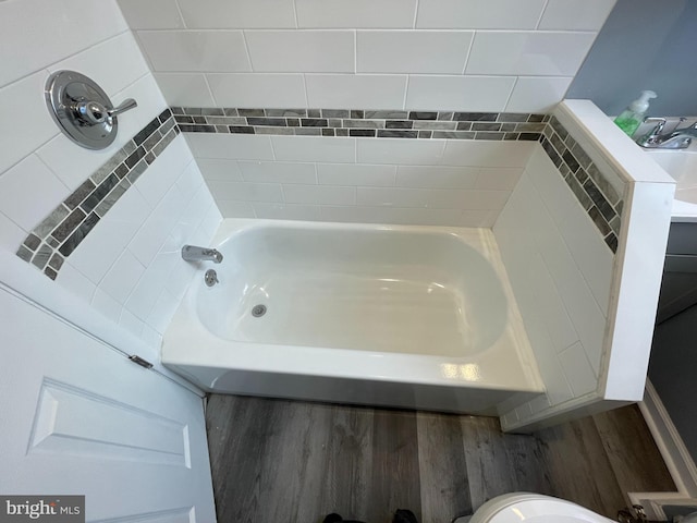 bathroom with a bath and hardwood / wood-style flooring