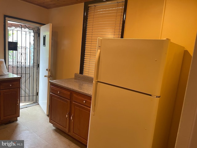 kitchen featuring light tile flooring and white fridge