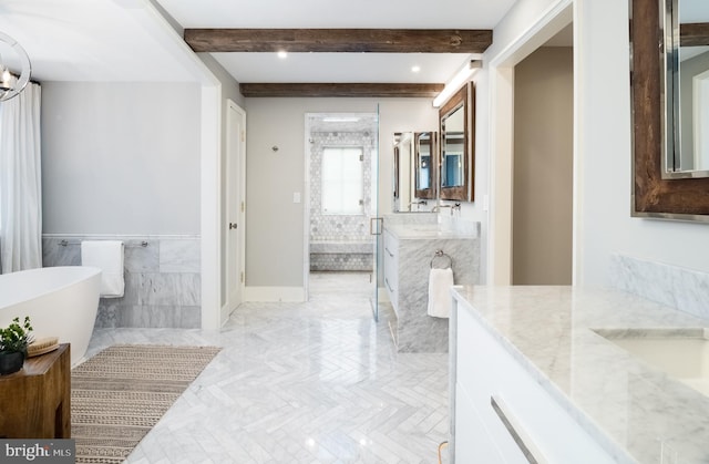 bathroom featuring a bath, vanity, beam ceiling, and tile walls