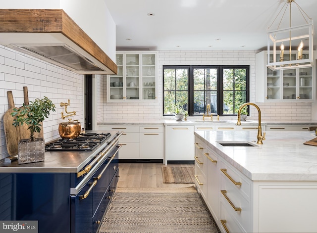 kitchen featuring a chandelier, hanging light fixtures, white cabinetry, and sink