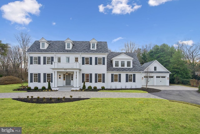 view of front of home with a front lawn, a balcony, and a garage