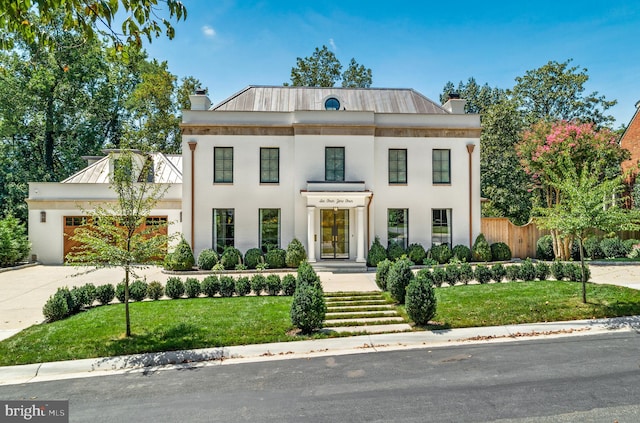 greek revival inspired property featuring a front lawn and a garage