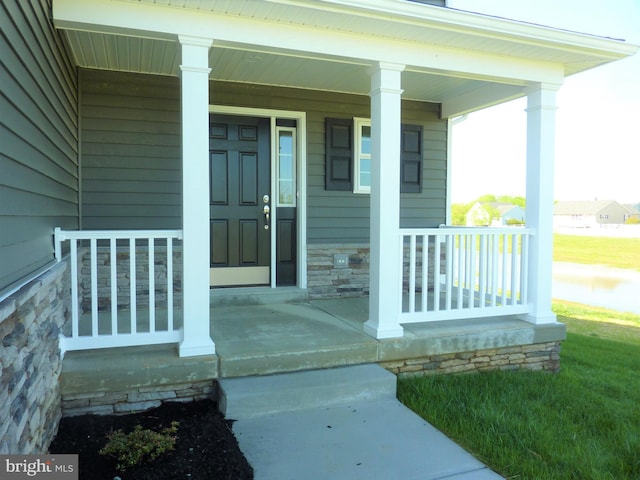 view of exterior entry featuring covered porch