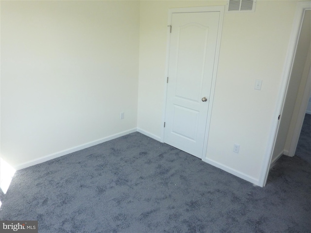 unfurnished bedroom featuring dark carpet