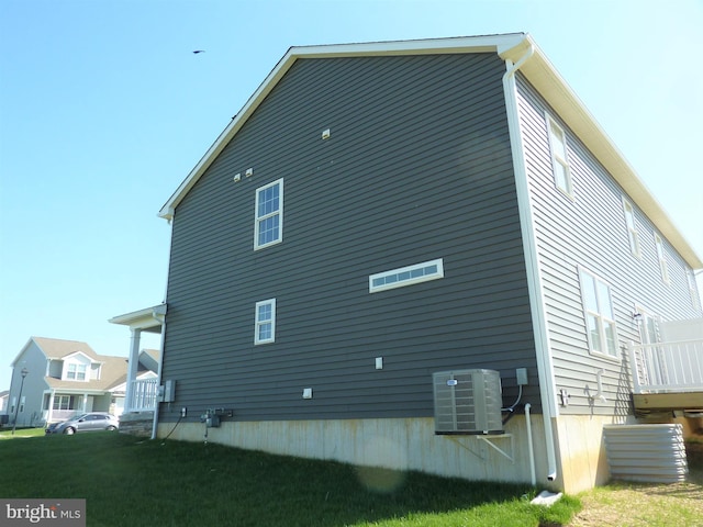 exterior space with central AC and a lawn