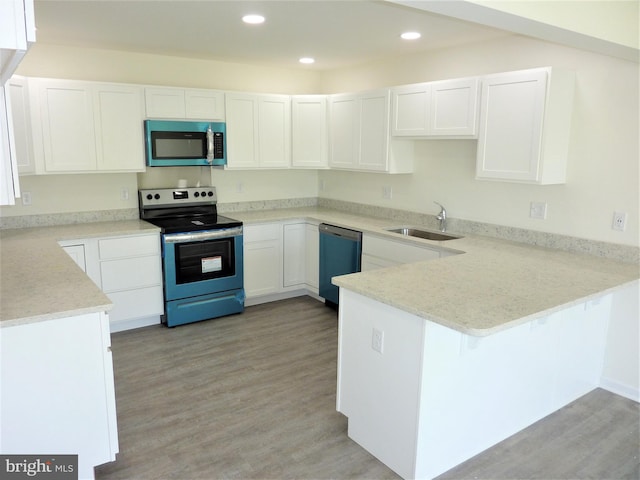 kitchen with appliances with stainless steel finishes, sink, light hardwood / wood-style flooring, and white cabinetry