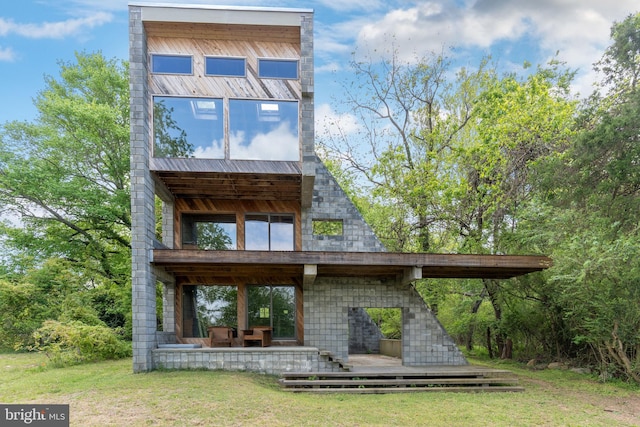 rear view of property featuring a yard