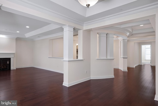 unfurnished living room with dark wood-type flooring, a raised ceiling, decorative columns, and ornamental molding