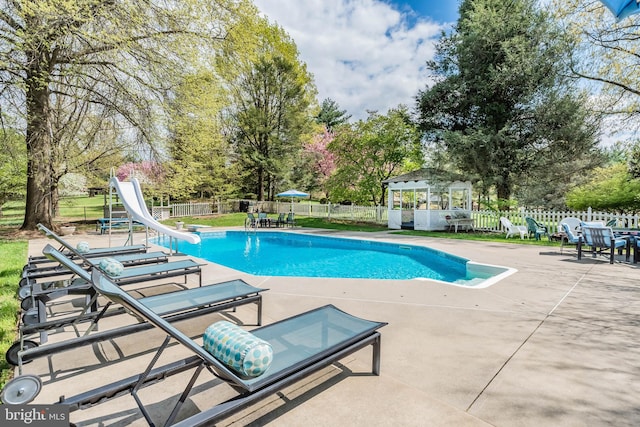 view of pool with a water slide, a gazebo, and a patio area