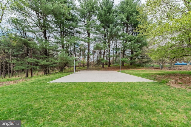 view of sport court featuring a yard