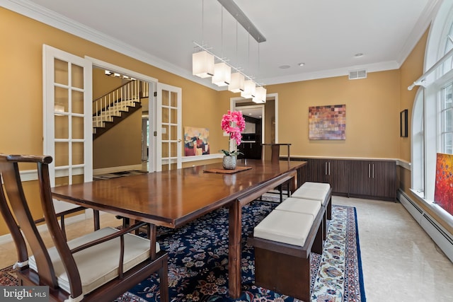 dining space featuring light colored carpet, ornamental molding, a baseboard heating unit, and french doors