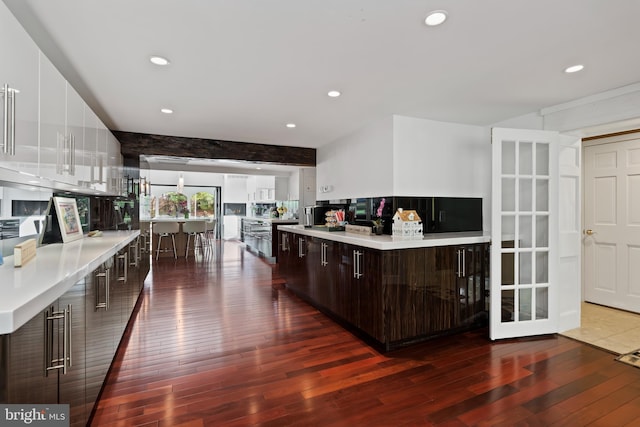 kitchen featuring dark hardwood / wood-style flooring, a center island, and dark brown cabinetry