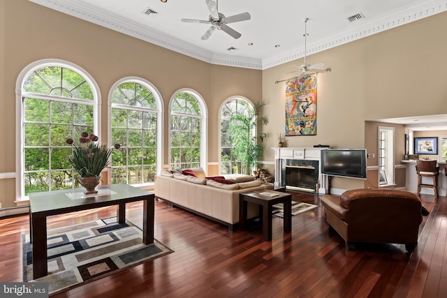 living room with a premium fireplace, crown molding, ceiling fan, and dark hardwood / wood-style flooring