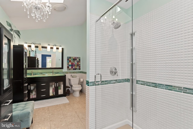 bathroom with toilet, a shower with shower door, tile flooring, an inviting chandelier, and vanity