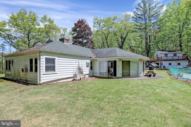 back of property with a swimming pool and a yard