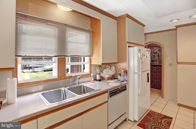 kitchen featuring white appliances, crown molding, sink, and light tile floors