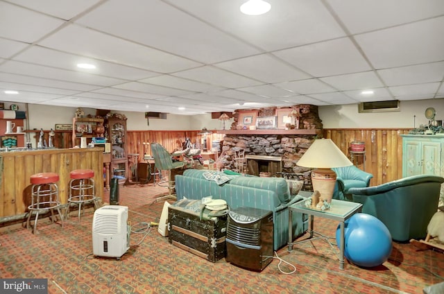 carpeted living room featuring indoor bar, a drop ceiling, and a fireplace