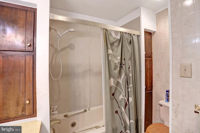 bathroom featuring shower / bath combo with shower curtain, toilet, and tile walls