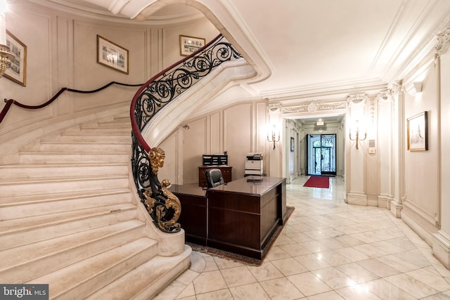 interior space with ornamental molding, light tile flooring, and ornate columns