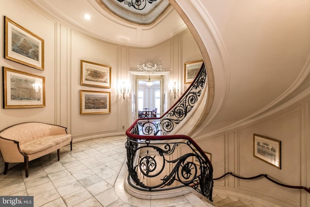 staircase featuring crown molding and light tile flooring