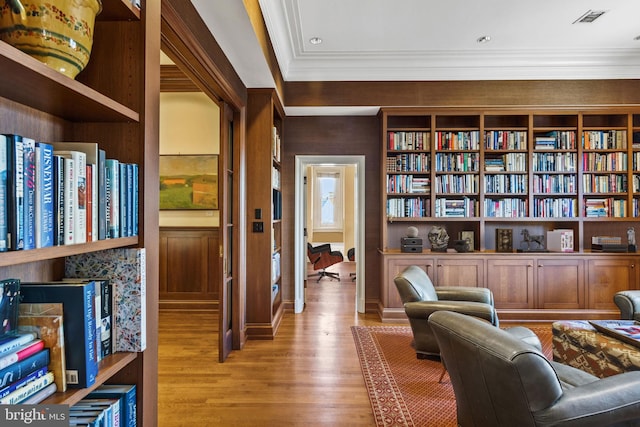 sitting room with light hardwood / wood-style flooring and ornamental molding