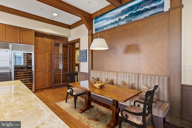 dining space featuring beam ceiling and light hardwood / wood-style floors