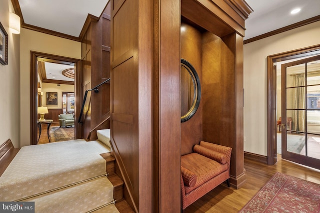 staircase with crown molding and wood-type flooring