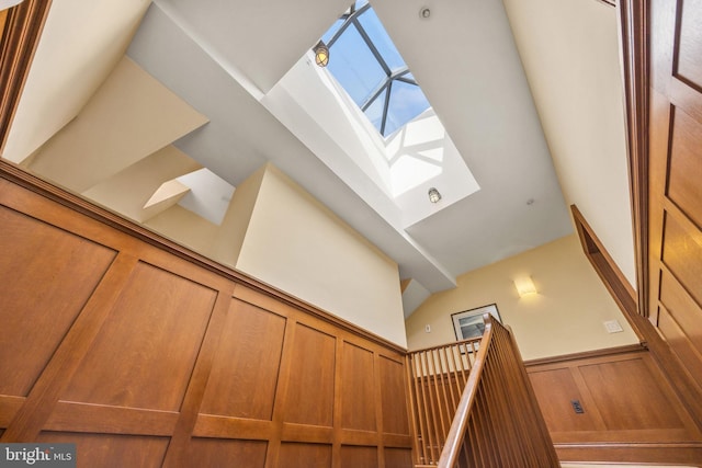 interior space with a skylight and a towering ceiling