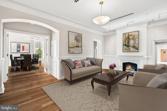 living room featuring ornamental molding and light hardwood / wood-style flooring