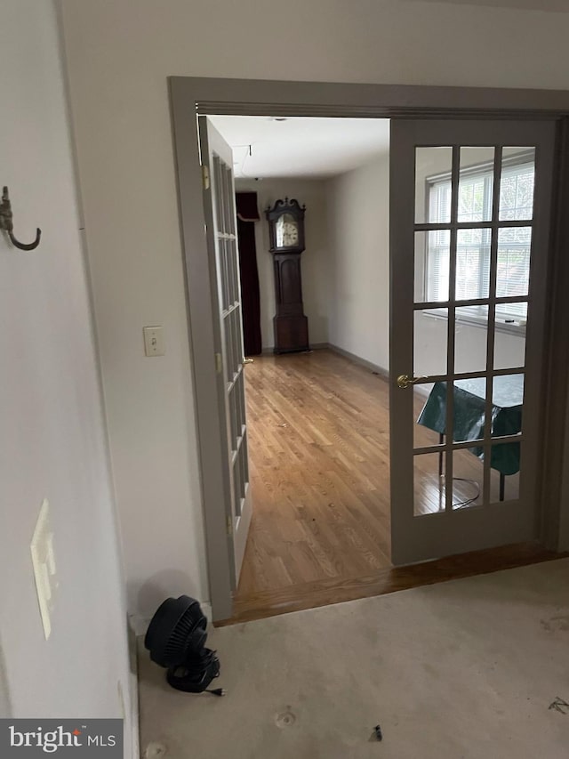 corridor with french doors and light wood-type flooring