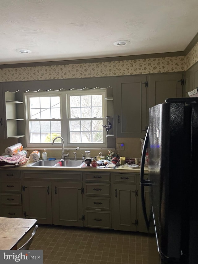 kitchen featuring crown molding, sink, gray cabinets, and black refrigerator