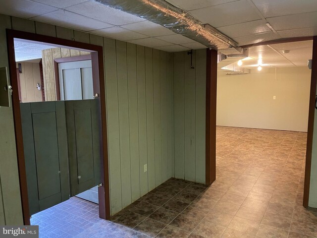 basement featuring tile flooring and a drop ceiling