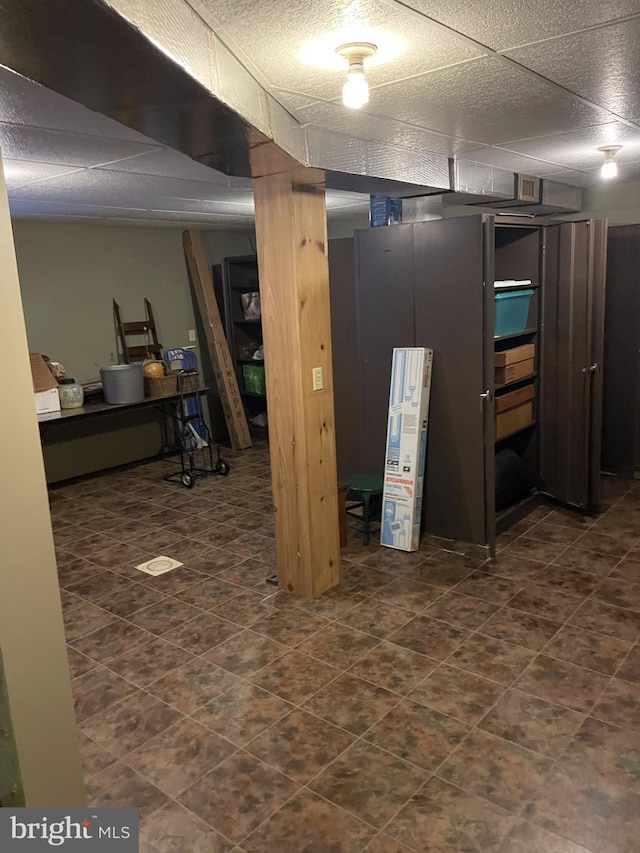 basement featuring dark tile flooring