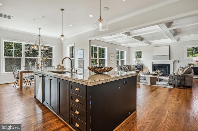 kitchen featuring coffered ceiling, dark hardwood / wood-style floors, pendant lighting, and a kitchen island with sink