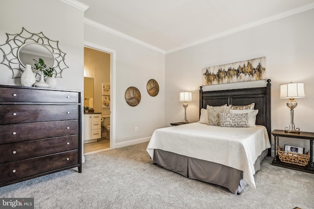 carpeted bedroom featuring ensuite bathroom and ornamental molding