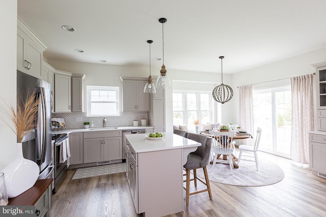 kitchen featuring a kitchen bar, plenty of natural light, light hardwood / wood-style floors, and a center island