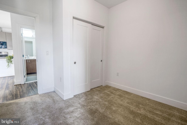 unfurnished bedroom with a closet and dark carpet