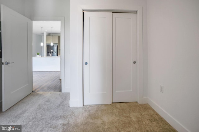 unfurnished bedroom with light carpet and a closet