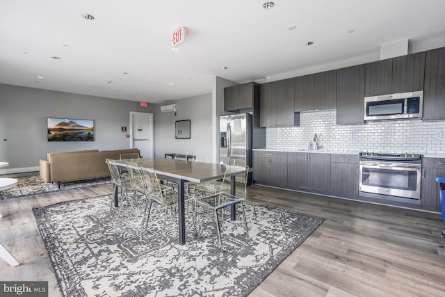 kitchen featuring tasteful backsplash, dark brown cabinetry, dark hardwood / wood-style flooring, and stainless steel appliances