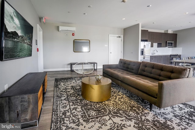 living room featuring dark hardwood / wood-style flooring, sink, and a wall unit AC