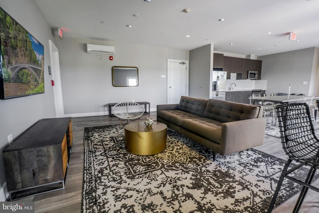 living room featuring sink, light wood-type flooring, and a wall mounted air conditioner