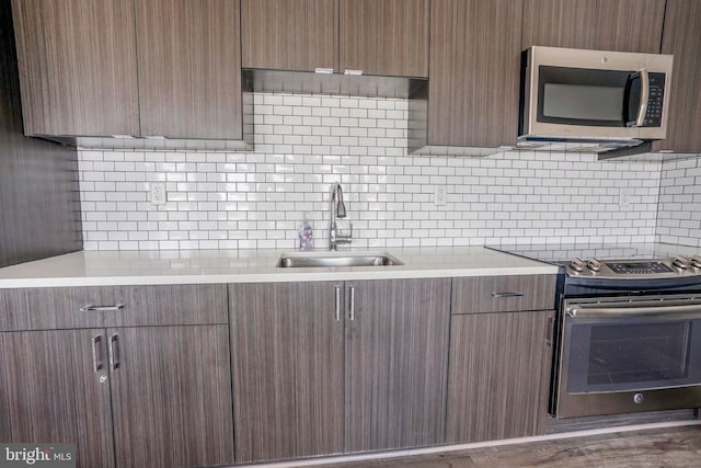 kitchen featuring dark hardwood / wood-style floors, sink, tasteful backsplash, and stainless steel appliances