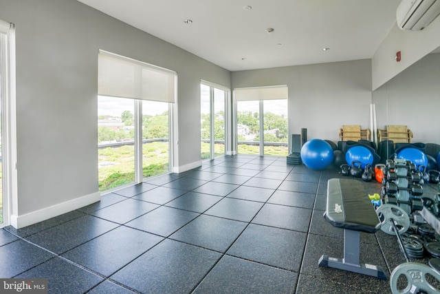 workout area with a wall mounted air conditioner and dark tile flooring