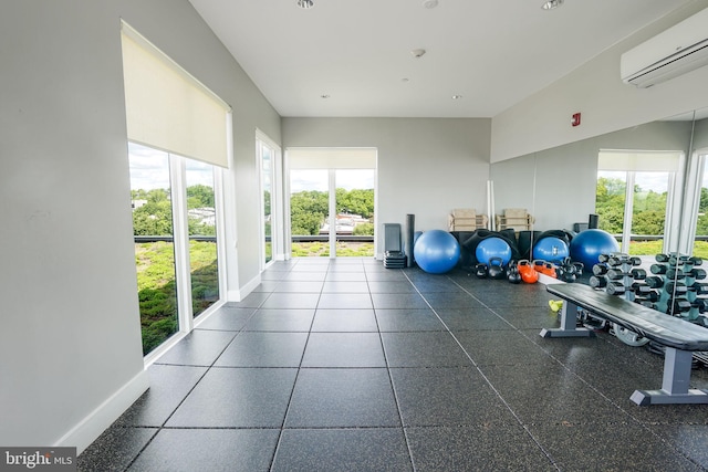 gym with dark tile flooring and a wall mounted AC