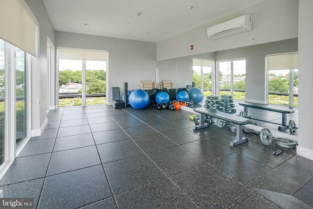 workout area featuring a wall mounted air conditioner and dark tile floors