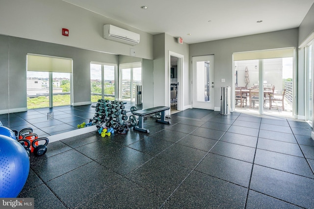 workout area featuring dark tile flooring and a wall unit AC