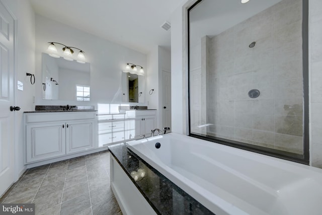 bathroom featuring a bath, large vanity, tile floors, and dual sinks