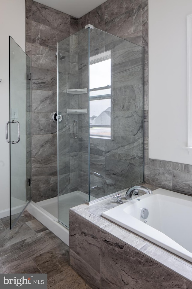 bathroom with tile flooring and independent shower and bath