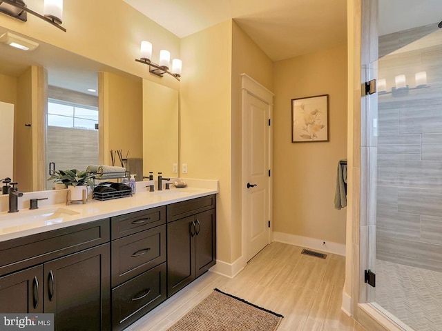 bathroom with tile floors, tiled shower, and double vanity